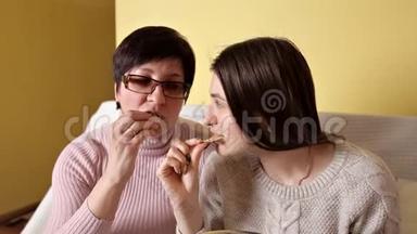 妈妈和女儿一边吃薯片，一边<strong>喝</strong>电视，一边<strong>喝可乐</strong>.. 家里的舒适气氛